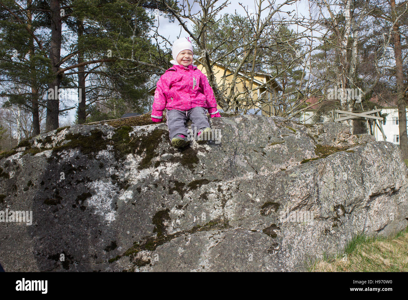 Laughing baby sul big stone Foto Stock