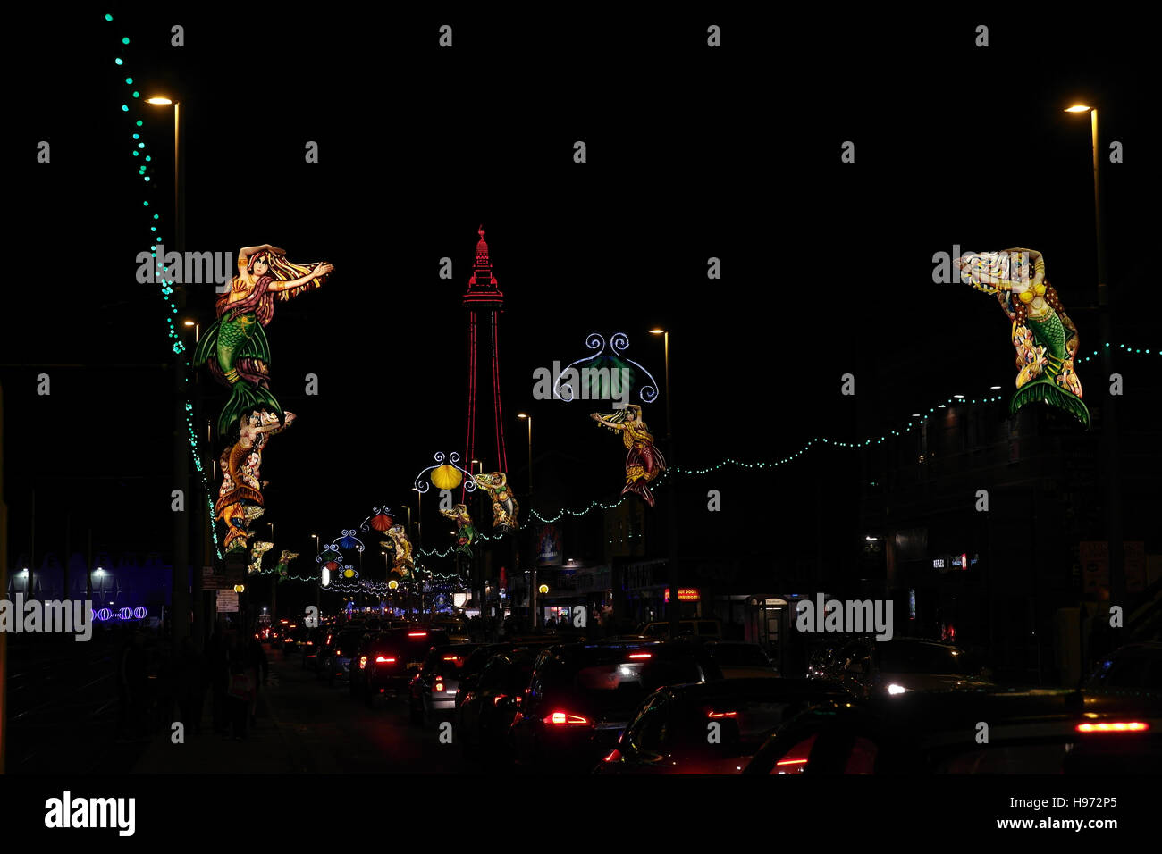 Vista dal nord Foxhall Pub a luci rosse Blackpool Tower, sirene sopra Central Promenade con il traffico, le luminarie di Blackpool Foto Stock