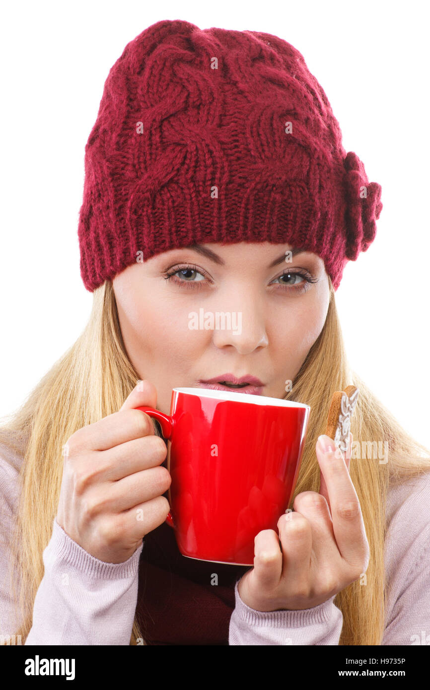 Donna sorridente indossando cappello di lana e scialle, tenendo gingerbread o cookie di festosa e rosso tazza di tè caldo, il tempo di Natale, sfondo bianco Foto Stock