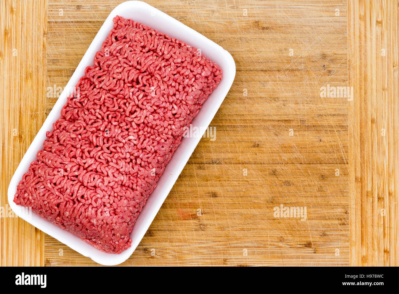 Cestella di crudo fresco macinato di manzo su un bambù tagliere pronto per essere usato in cucina come un ingrediente di cottura, vista aerea Foto Stock