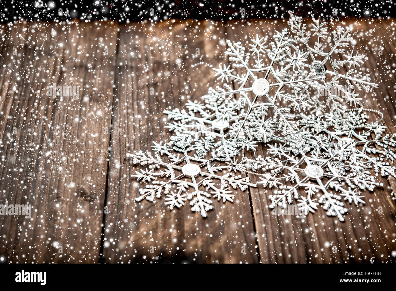 Decorazione di Natale fiocchi di neve caduta con effetto neve. Rustico sfondo di legno Foto Stock