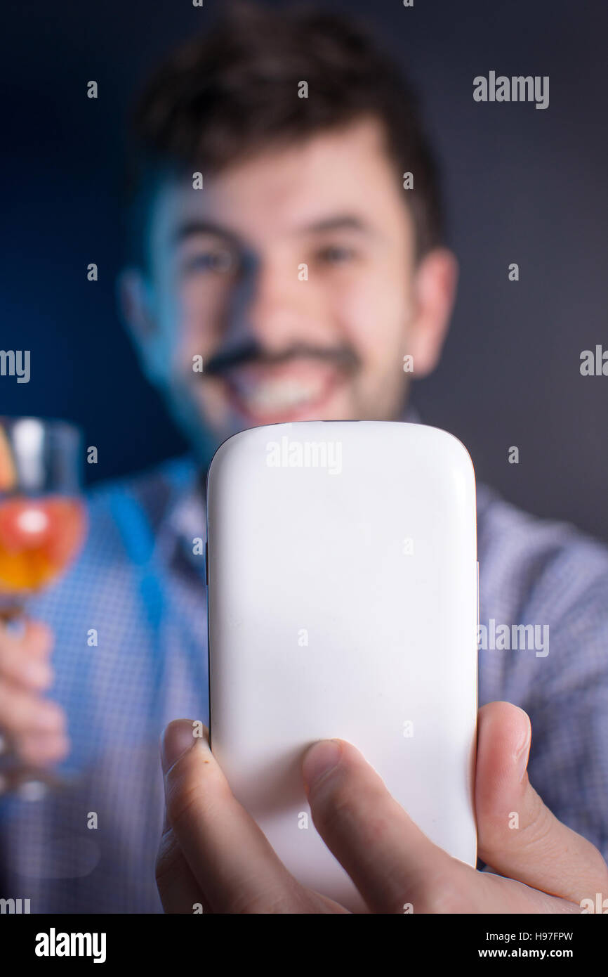 Uomo pazzo facendo una selfie con un cocktail presso il partito Foto Stock