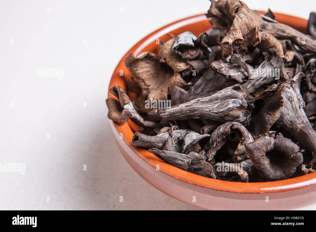 Ciotola di argilla pieno di corno dell'abbondanza di funghi. Isolato Foto Stock