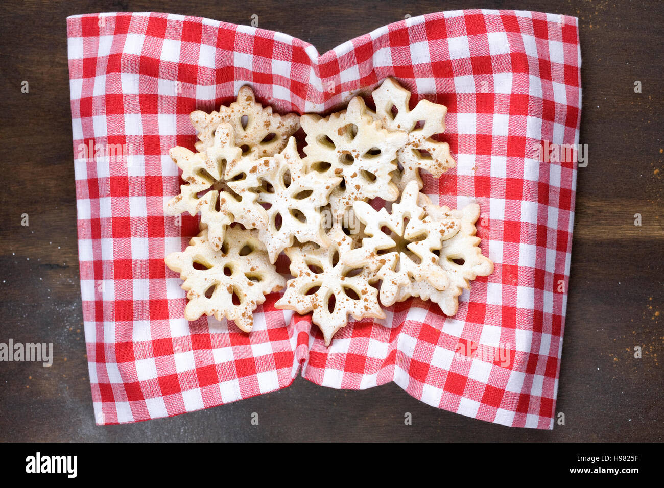 In casa il simbolo del fiocco di neve i cookie su un rosso controllato panno. Foto Stock