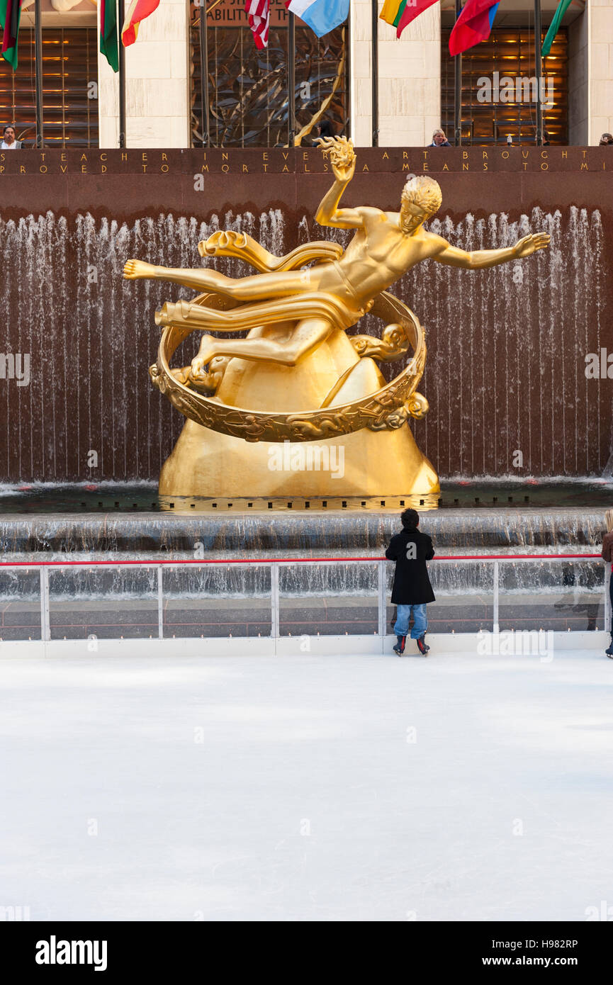 Un giovane ragazzo guarda la scultura Prometheus di Paul Howard Manship, la pista di pattinaggio su ghiaccio al Rockefeller Center di Midtown Manhattan, New York Foto Stock