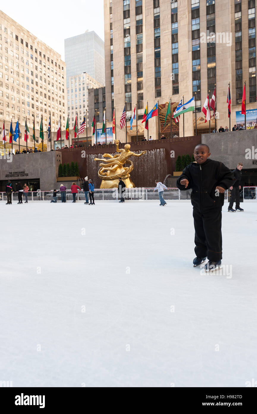 Giovani afro-americani che pattinano vicino alla macchina fotografica, pista di pattinaggio su ghiaccio del Rockefeller Center, scultura Prometheus di Paul Howard Manship, New York Foto Stock