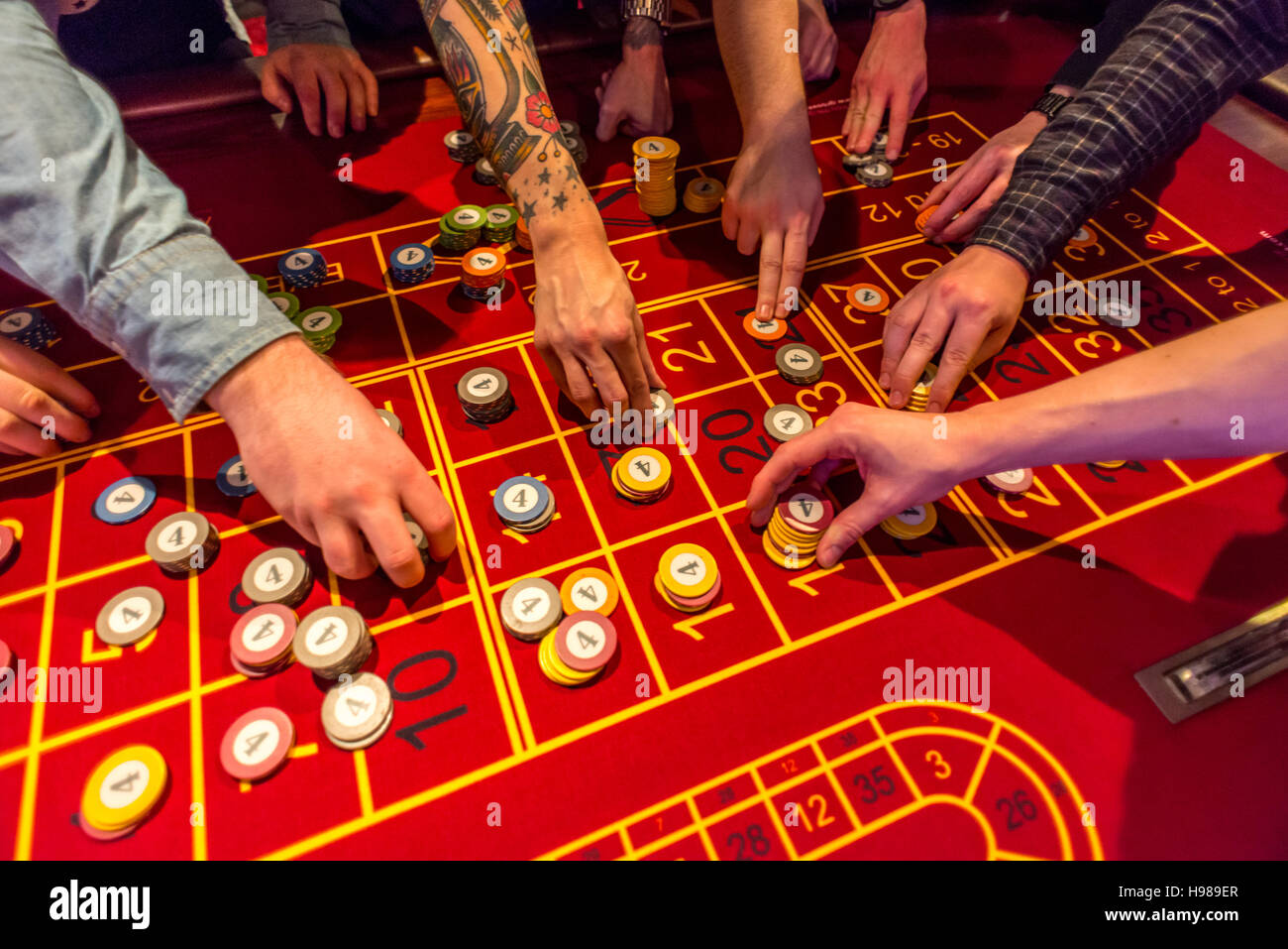 Giovani uomini su una notte fuori gioco d'azzardo e il gioco della roulette Foto Stock