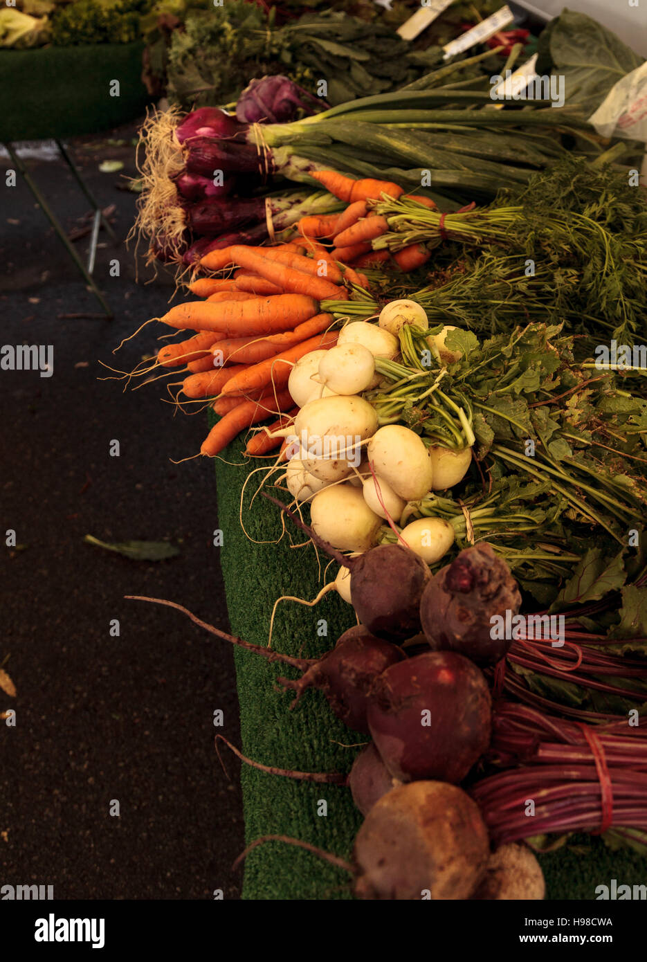 Le barbabietole giallo, arancio di carote e cipolle rosse cresciuto su una fattoria e visualizzate in un mercato degli agricoltori Foto Stock