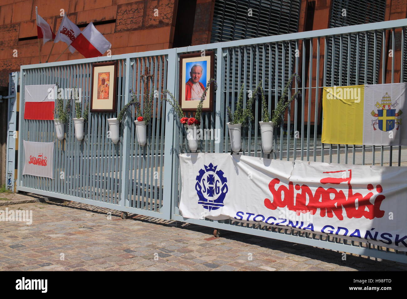 Una fotografia a colori delle porte dell'ex cantiere Lenin di Danzica. Il Centro europeo di solidarietà può essere intravisto a sinistra. Foto Stock