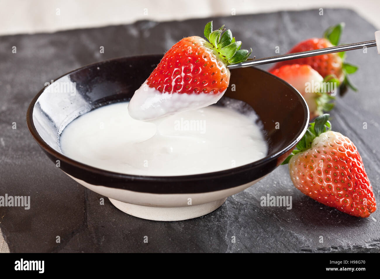 Organico fresco lo yogurt greco con fragole su uno sfondo Foto Stock