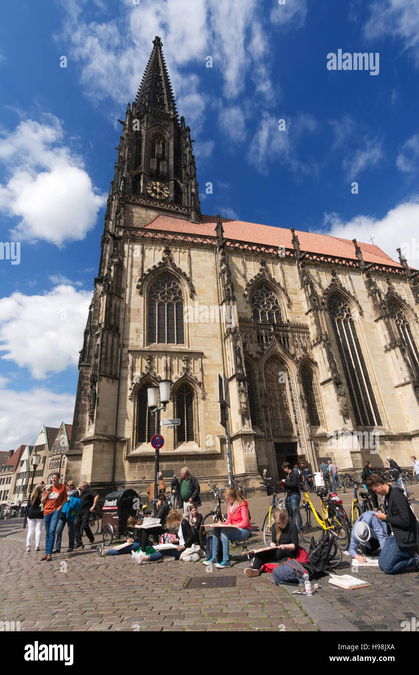 Gli studenti di arte delineando nella piazza davanti a San Lambert la Chiesa in Munster, Germania, Europa Foto Stock