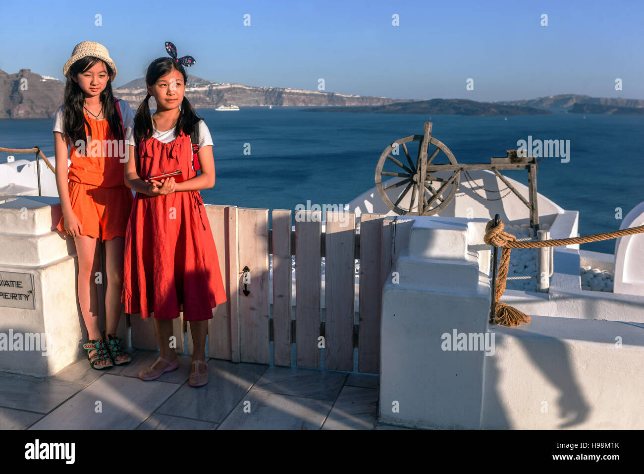 Due asiatiche, adolescenti, ragazze Oia Santorini turisti isola greca, Grecia Isole Europa turismo Grecia villeggianti giovani adolescenti Foto Stock