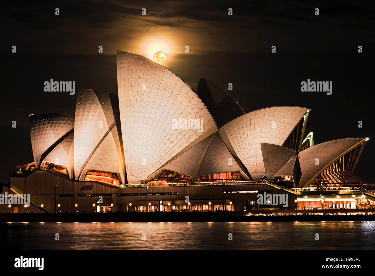 Sydney, Australia - 15 Novembre 2016: Super piena di rusty moon rising oltre la Opera House di Sydney in Australia durante l'astronomia unico evento sulla notte oscura Foto Stock