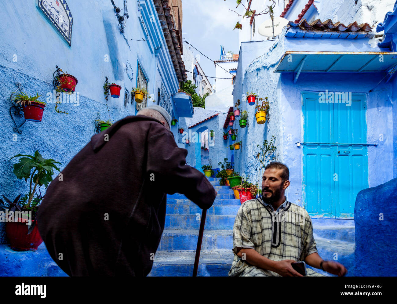 Un uomo anziano a camminare su una strada colorato nella Medina, Chefchaouen, Marocco Foto Stock