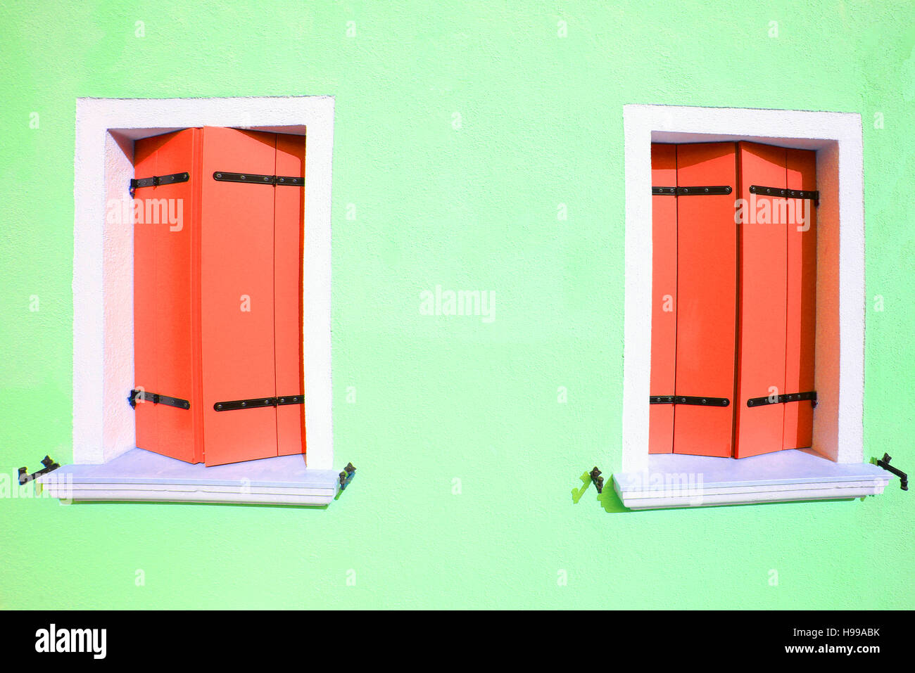 Due finestre chiuse in casa colorati sull'isola di Burano nella laguna di Venezia vicino a Venezia in Italia Foto Stock