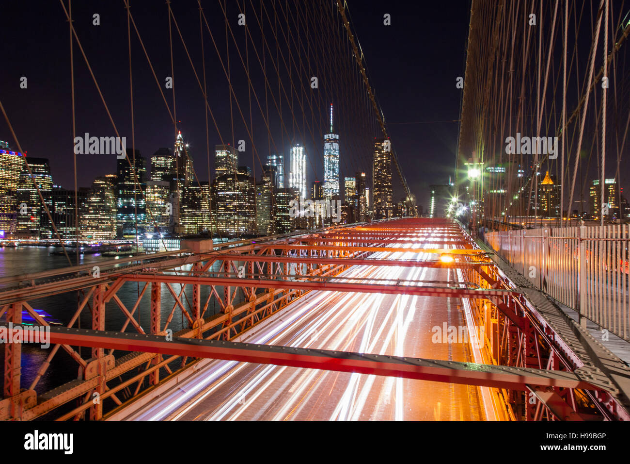 Il ponte di Brooklyn a notte con auto sentieri di luce e il quartiere finanziario in background , Stati Uniti d'America. Foto Stock