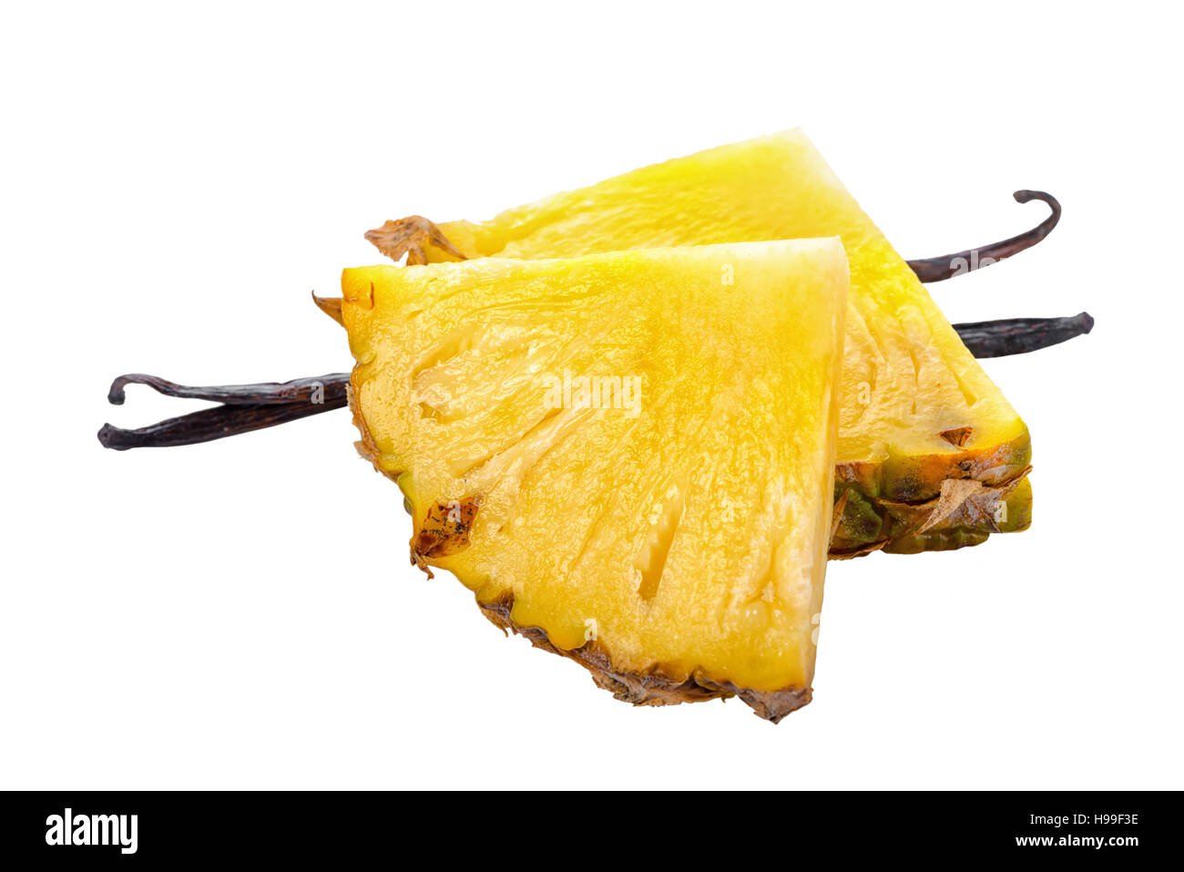 Composizione di baccelli di vaniglia con fette di ananas maturo isolato su sfondo bianco, decorazione per il tuo prodotto, close up Foto Stock