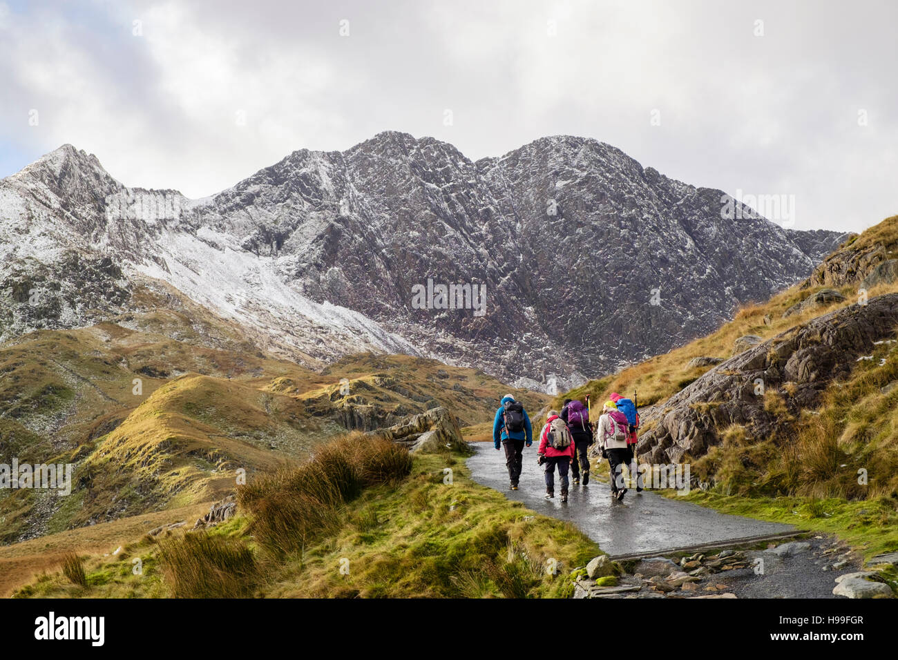 Gli escursionisti trekking sui minatori 'Via in Snowdon a ferro di cavallo con Y Lliwedd avanti e la neve in inverno. Parco Nazionale di Snowdonia (Eryri) North Wales UK Foto Stock