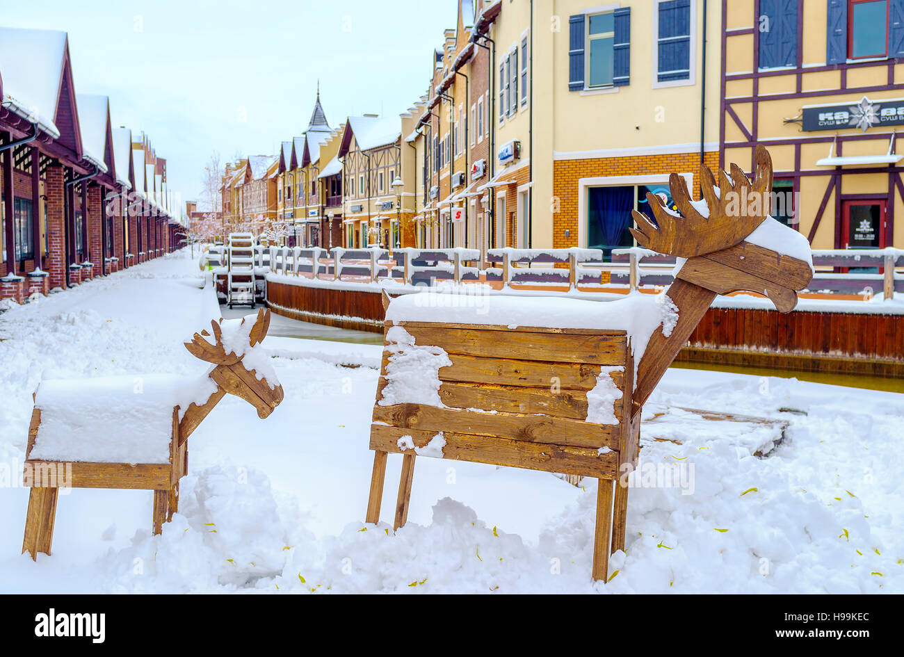 Le alci in legno ricoperta di neve in olandese in stile Revival quartiere dello shopping con la ruota di acqua in un canale, Kiev Foto Stock