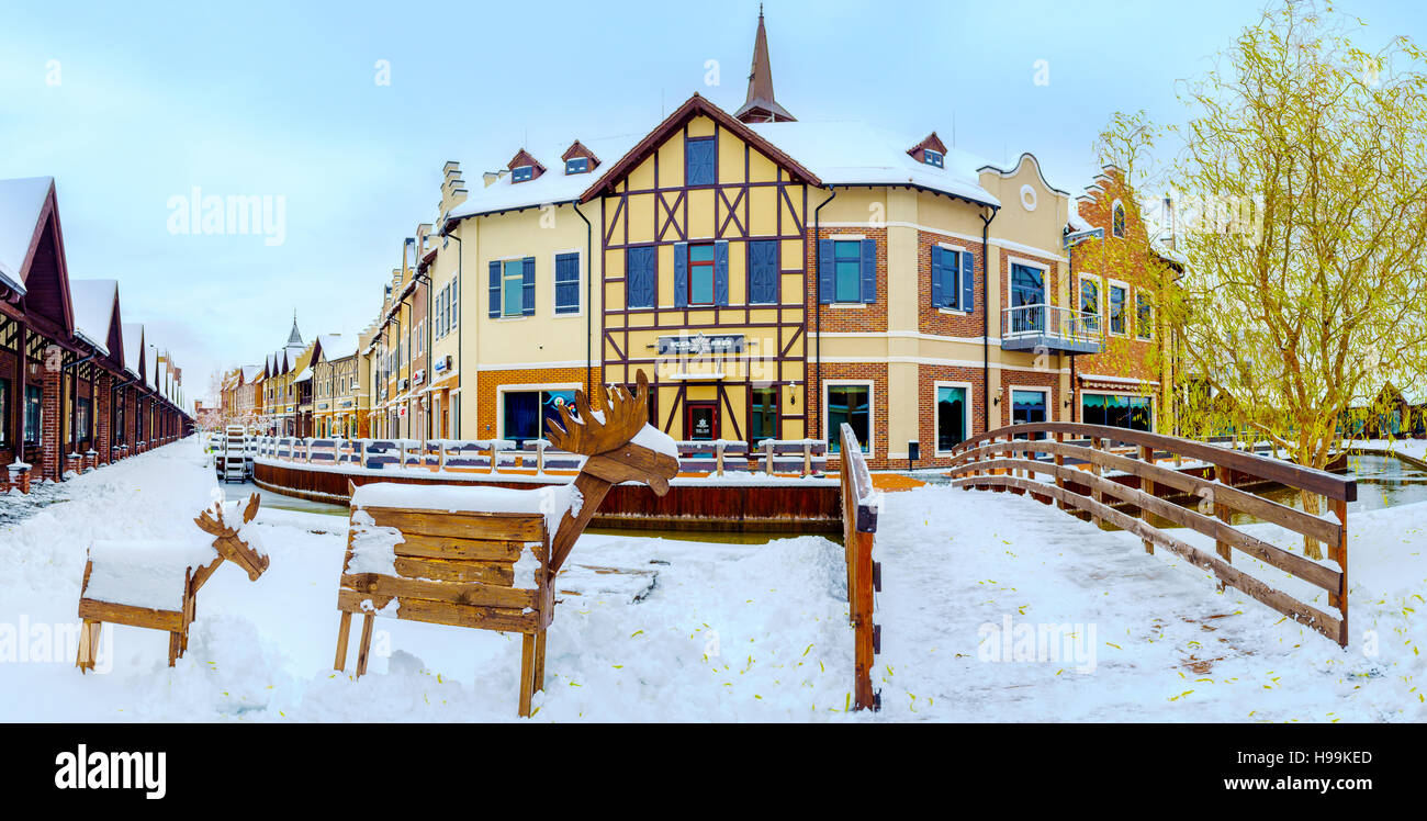 Panorama di stile olandese shopping City con le sculture in legno di alci presso la banca nevoso del canal, Kiev Foto Stock