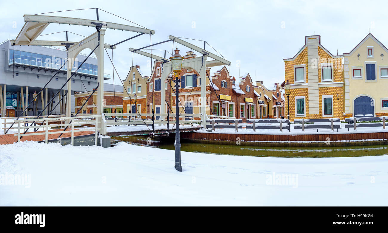 Il terrapieno nevoso del canale in neerlandese stile Revival città dello shopping con il ponte levatoio che conduce alla boutique di moda, Kiev Foto Stock
