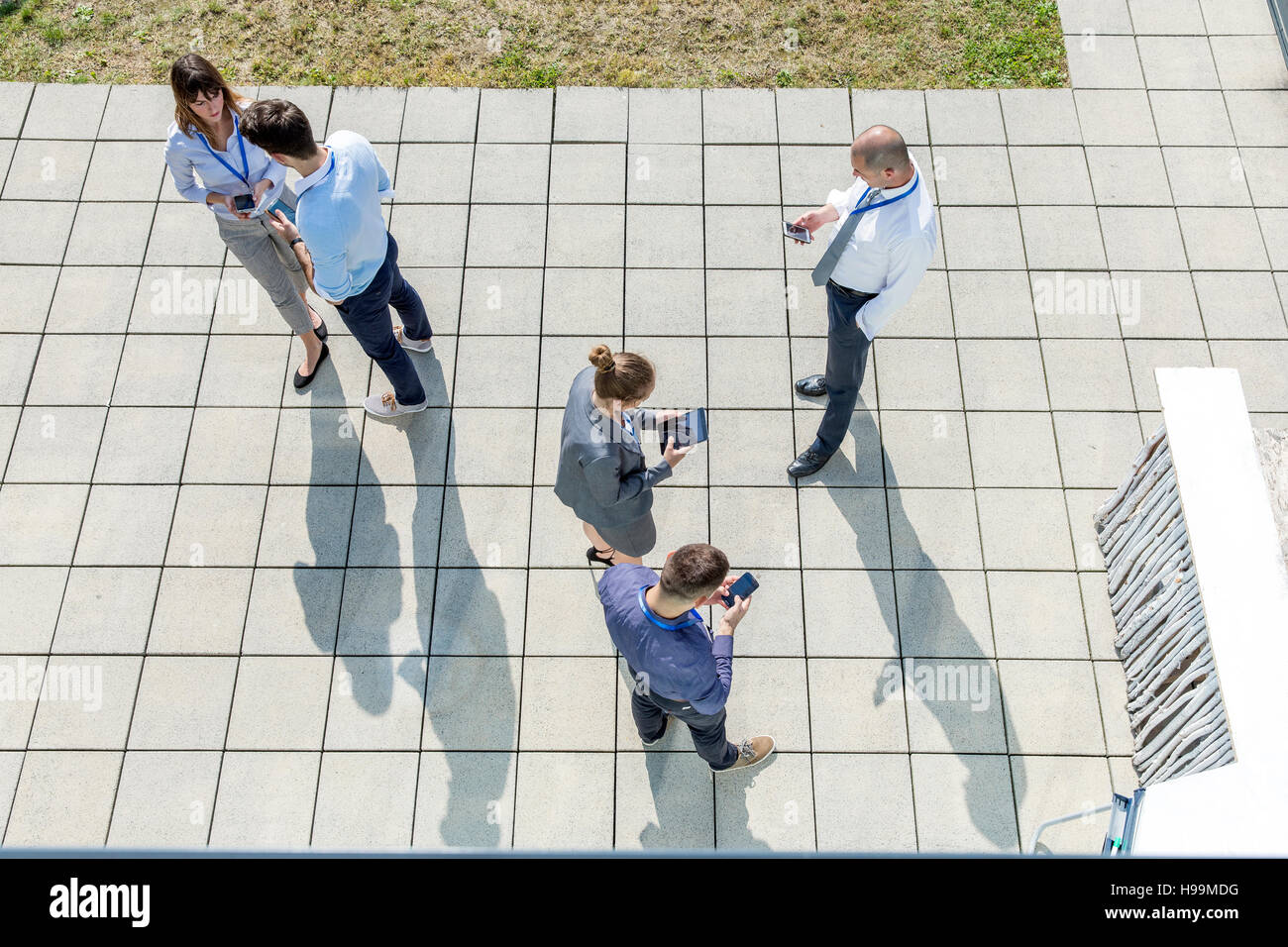 Un gruppo di persone di affari utilizzando gli smartphone e compresse digitale all'aperto Foto Stock