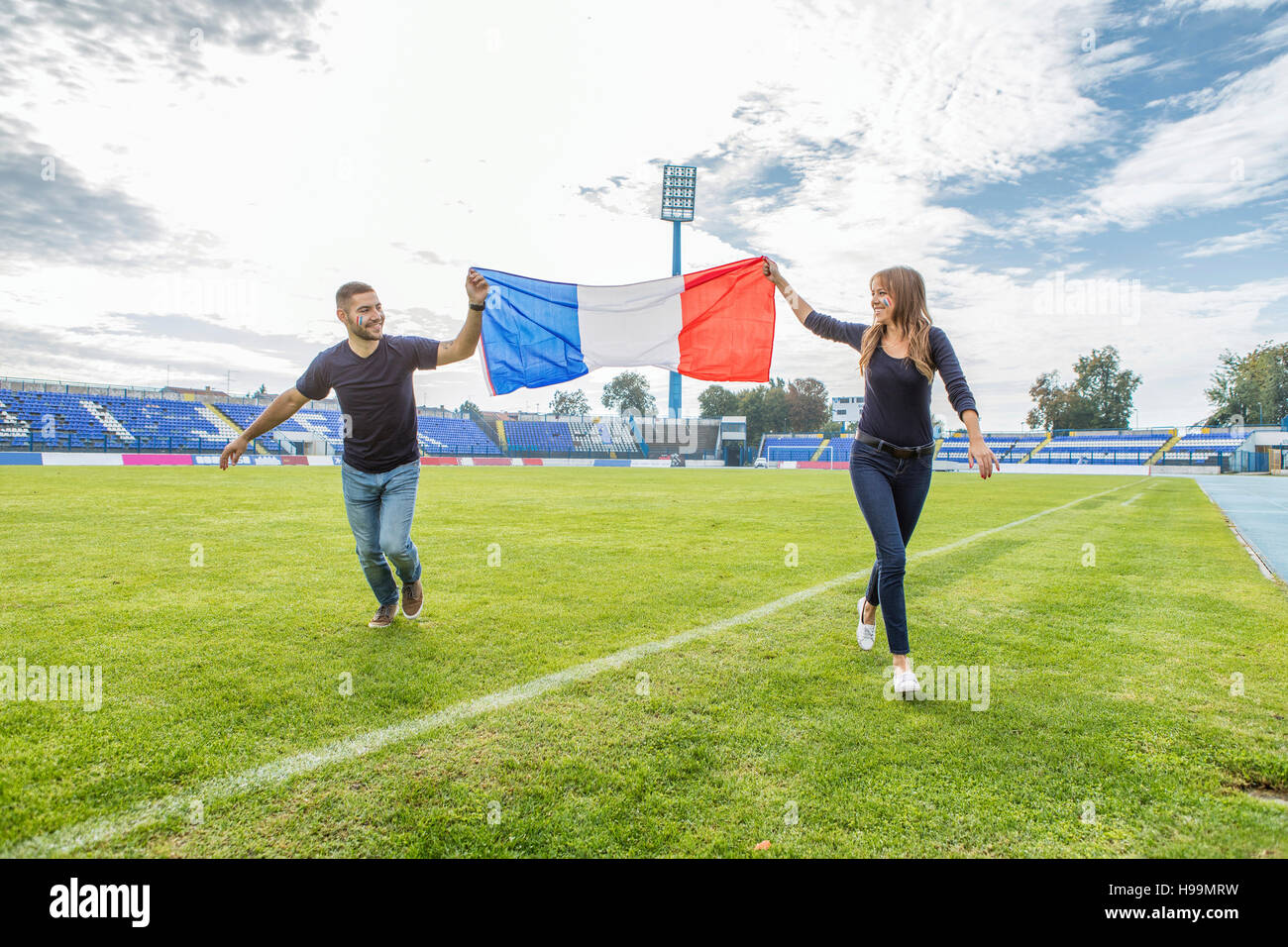 Coppia giovane sul campo da calcio azienda bandiera francese Foto Stock
