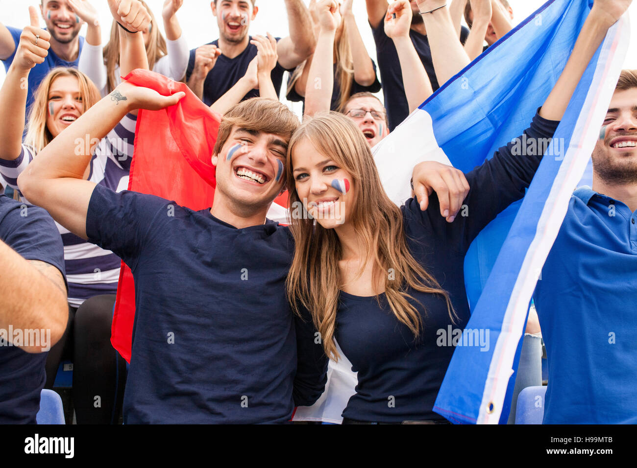 Un gruppo di appassionati di calcio celebrando con bandiera francese Foto Stock