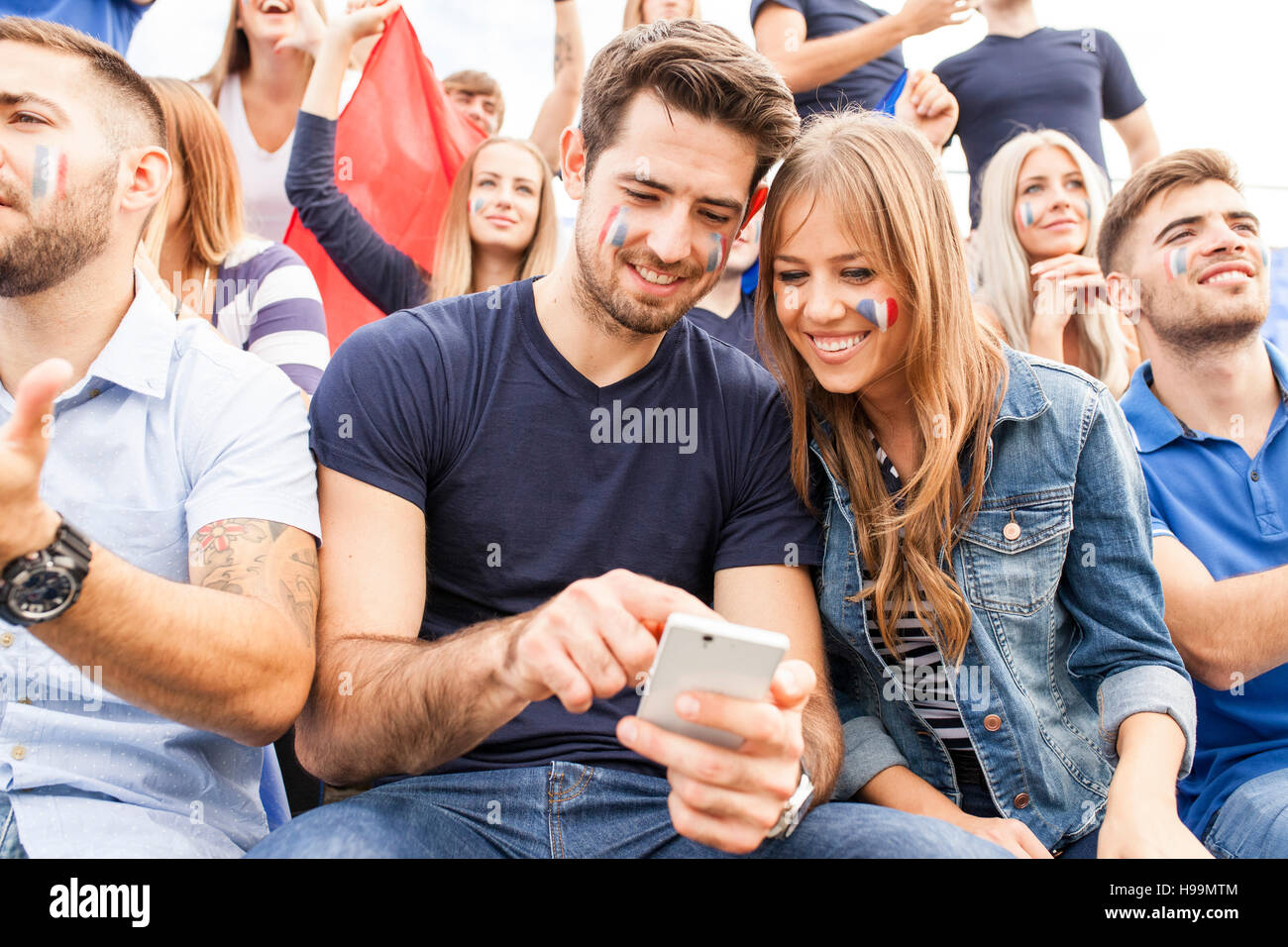 Gli appassionati di calcio con lo smartphone per la messaggistica di testo Foto Stock