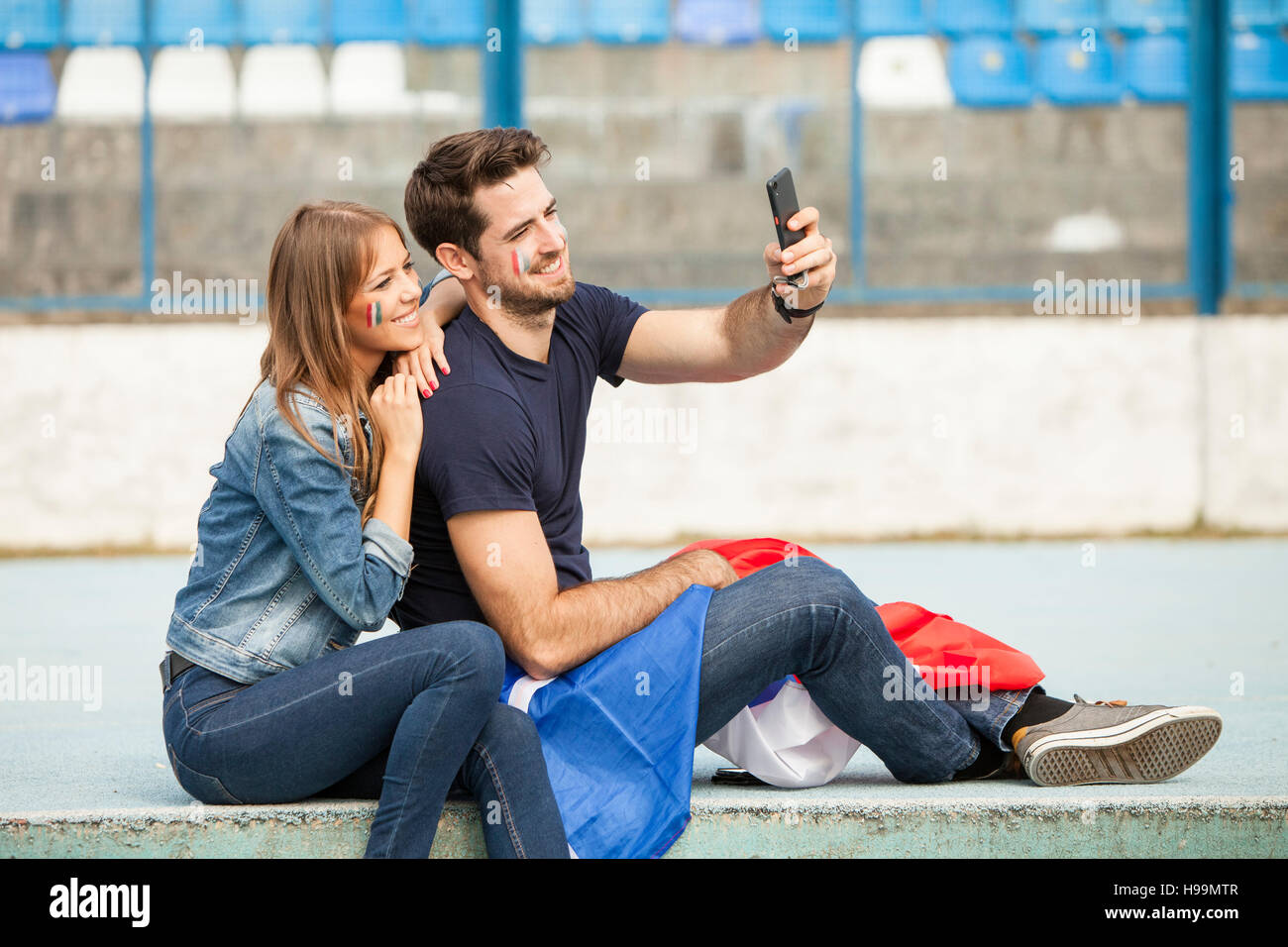 Coppia giovane con bandiera francese prendendo un selfie Foto Stock
