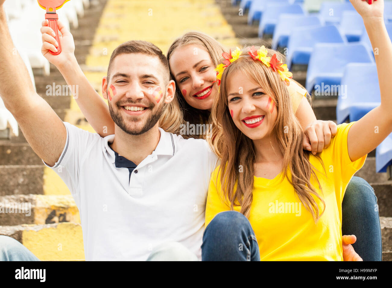 Tre gli appassionati di calcio il tifo in stadium Foto Stock