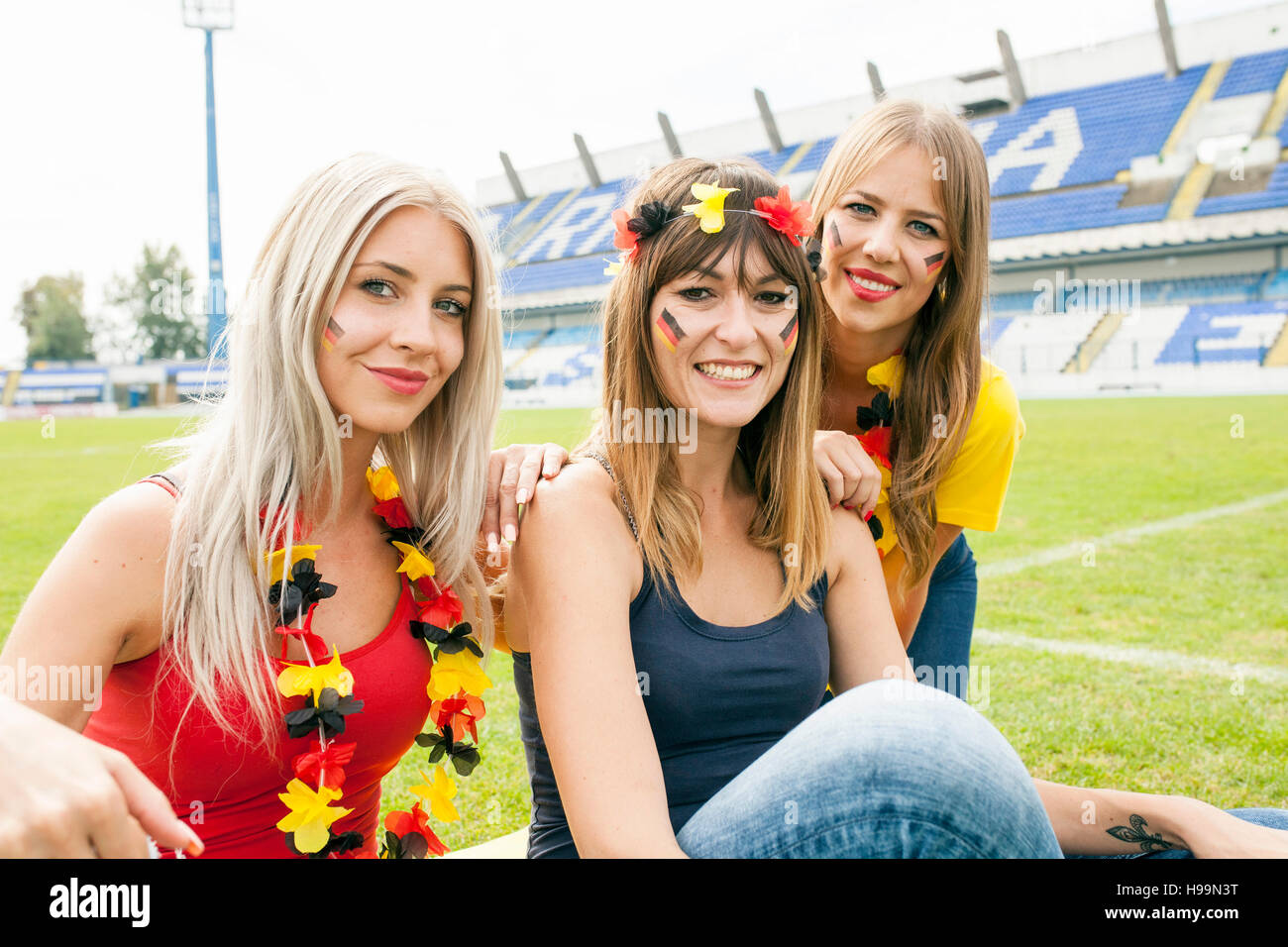 Ritratto di tre femmina tedesca soccer fans in stadium Foto Stock
