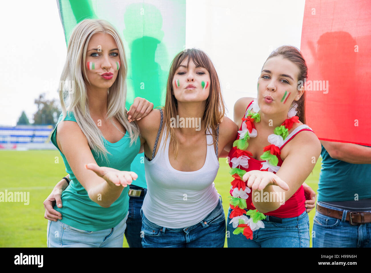 Tre donne appassionati di calcio soffia un bacio Foto Stock