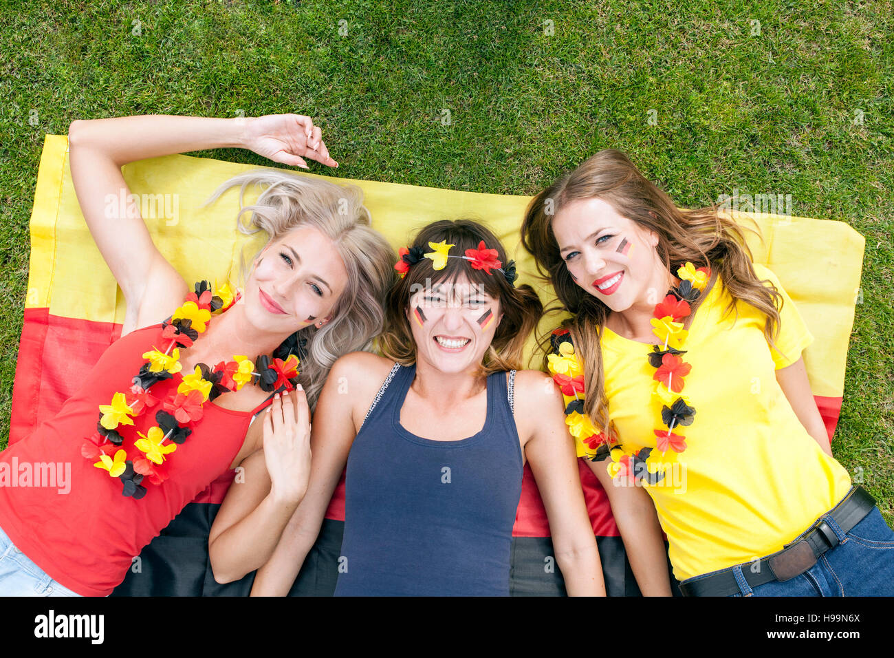 Ritratto di tre femmina tedesca soccer fans in stadium Foto Stock