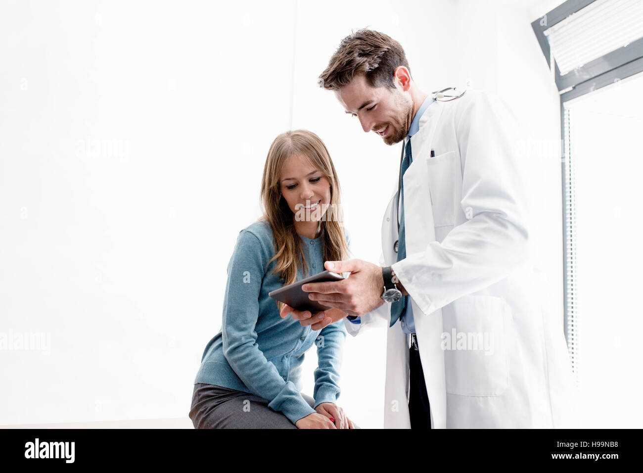 Medico e paziente di sesso femminile guardando a tavoletta digitale Foto Stock