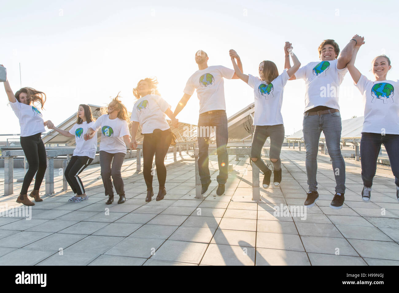 Gruppo di adolescenti ambientalisti jumping e rasserenanti Foto Stock