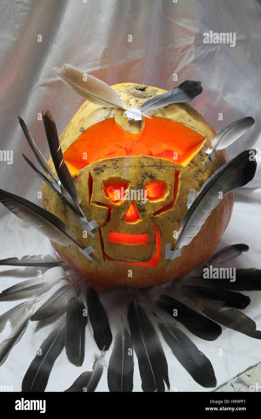 Succosa grande zucca arancione con cranio in pirate hat decorate feathes lanterna sulla notte di Halloween party Foto Stock