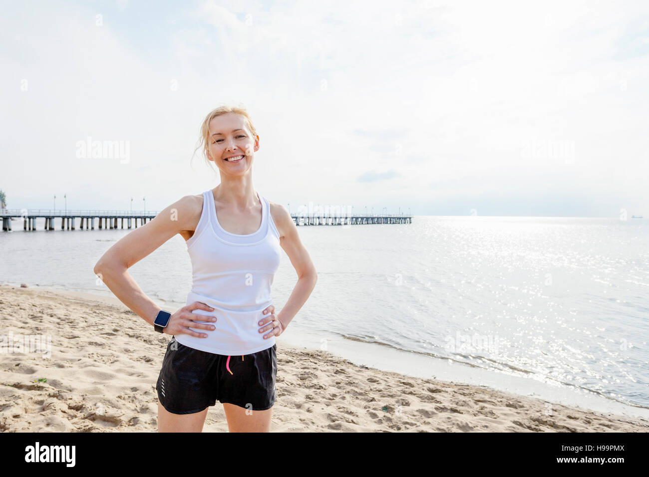 Donna in abbigliamento sportivo sulla spiaggia Foto Stock