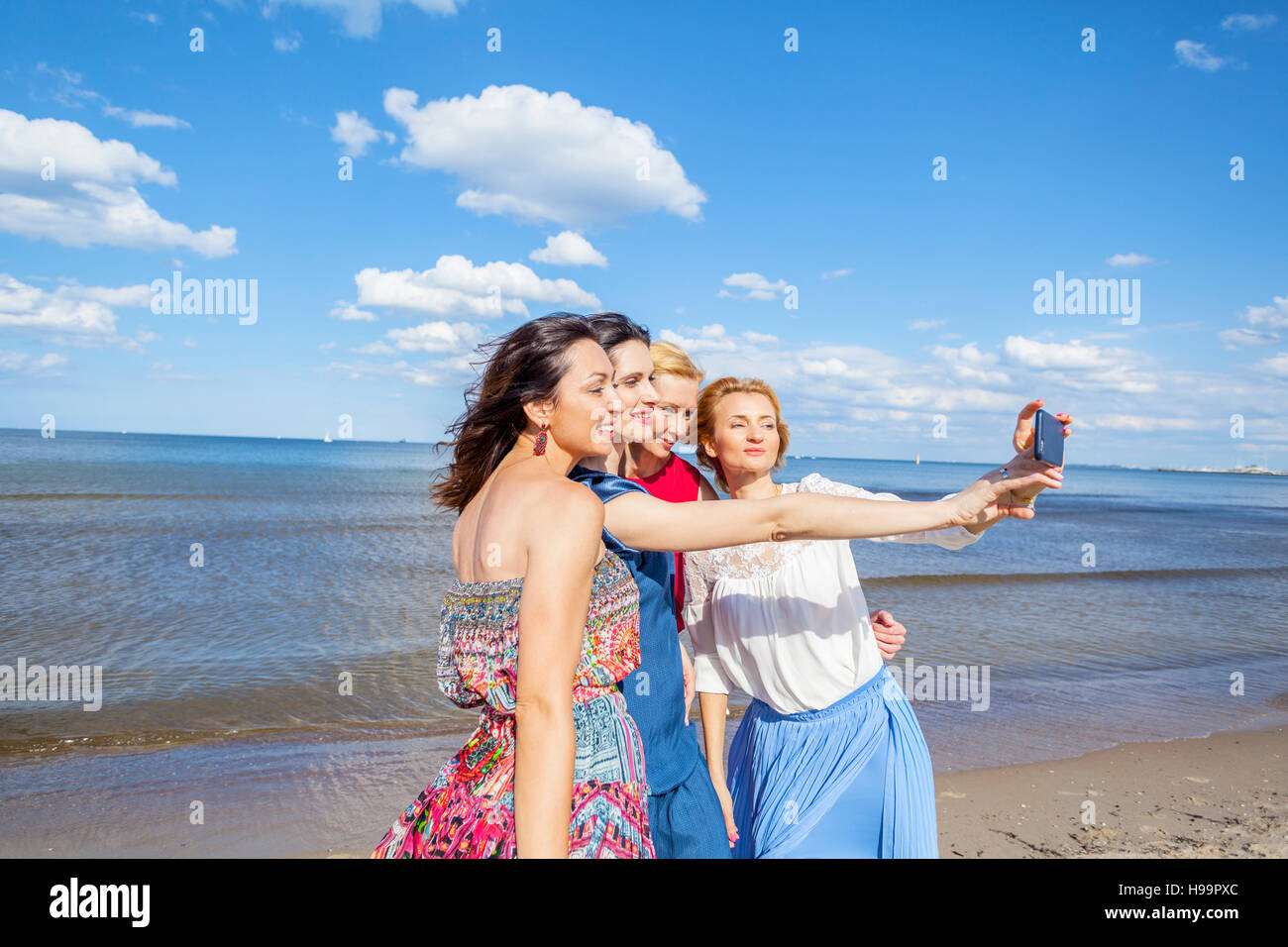 Le donne sulla spiaggia prendendo un selfie Foto Stock