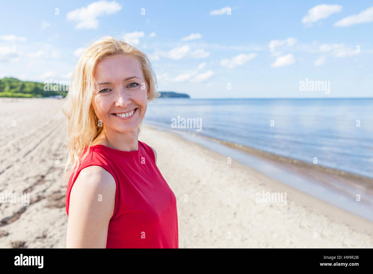Ritratto di donna con capelli biondi sulla spiaggia Foto Stock