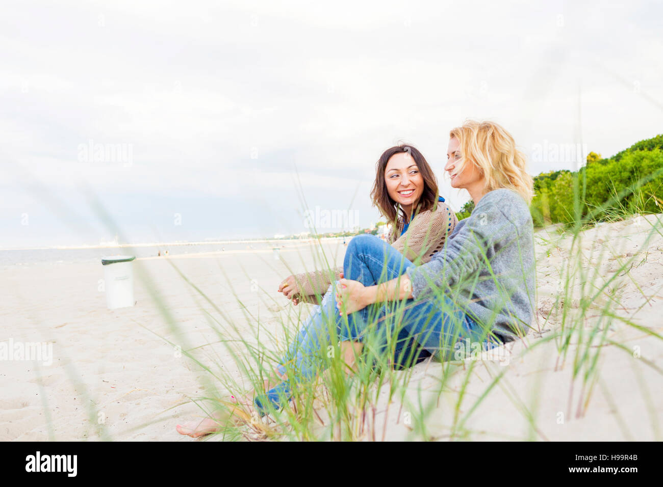 Due amiche in relax sulla spiaggia sabbiosa Foto Stock