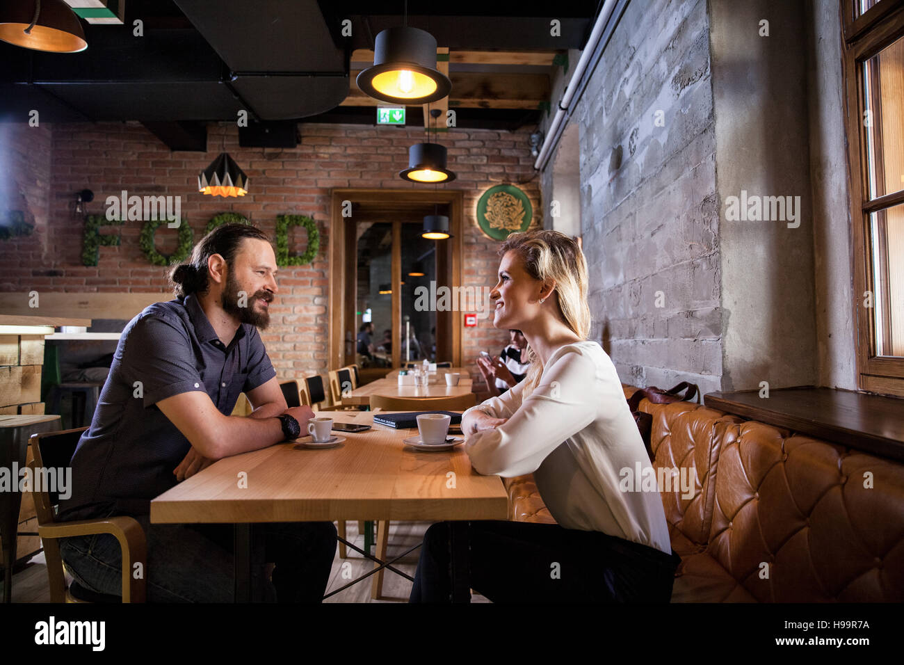 Matura in coffee shop avente una conversazione Foto Stock