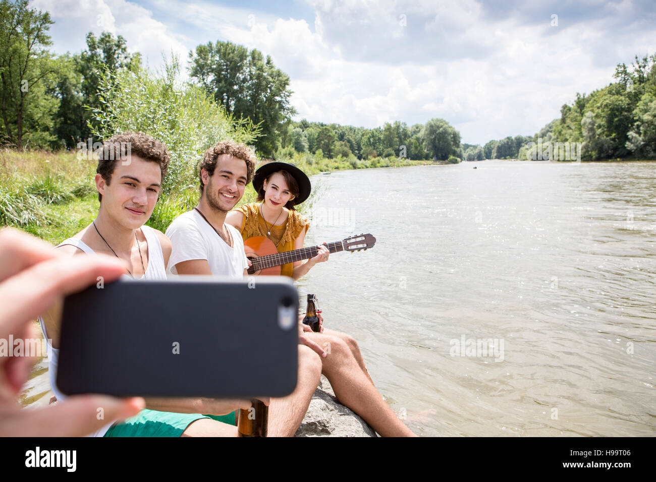Gruppo di amici in relax sulla riva del fiume Foto Stock