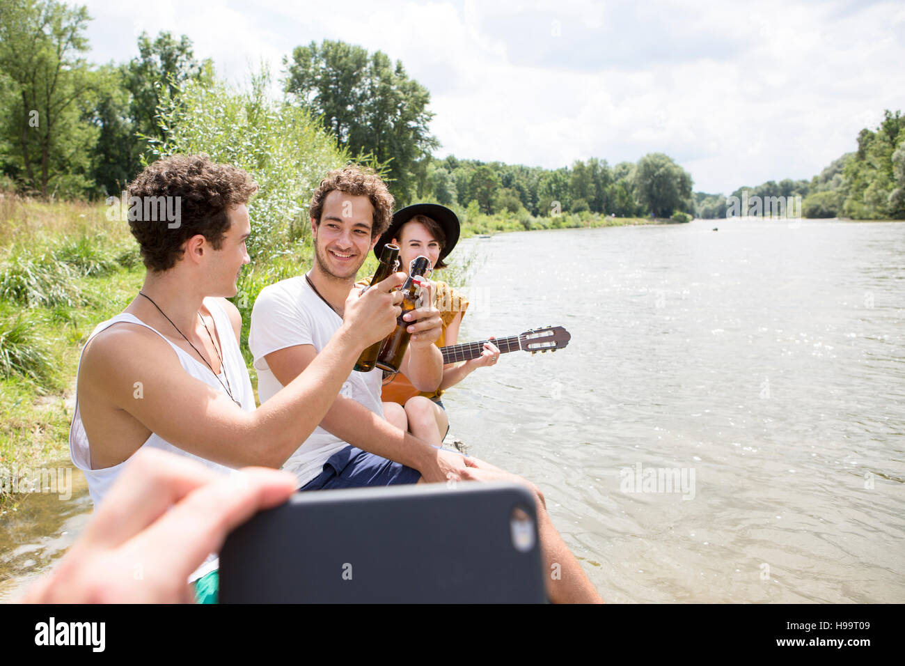 Gruppo di amici in relax sulla riva del fiume Foto Stock