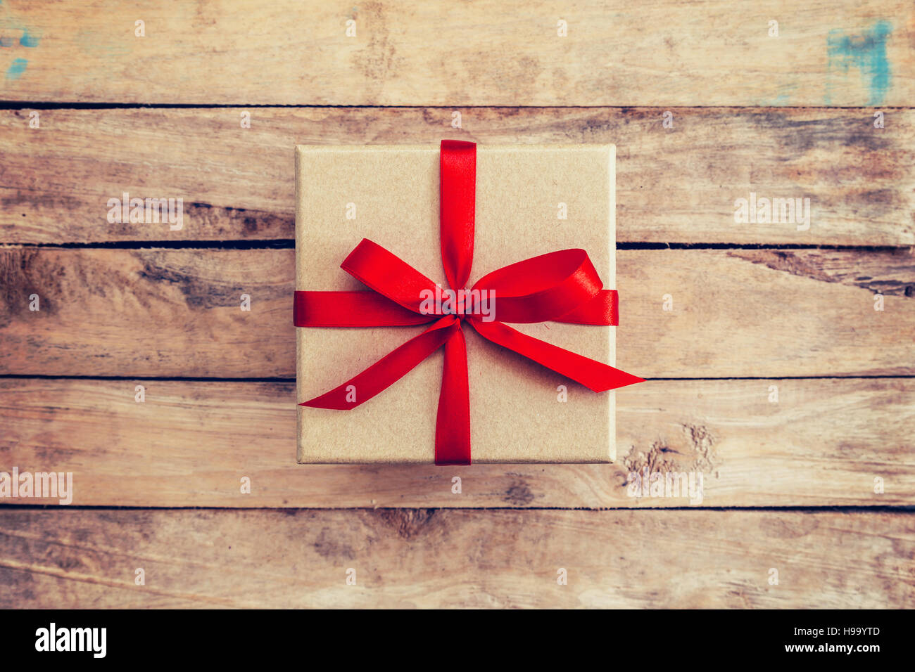 Brown box regalo su sfondo di legno. Vintage scatola regalo su sfondo di legno. Confezione regalo con nastro rosso su uno sfondo di legno con lo spazio. Foto Stock