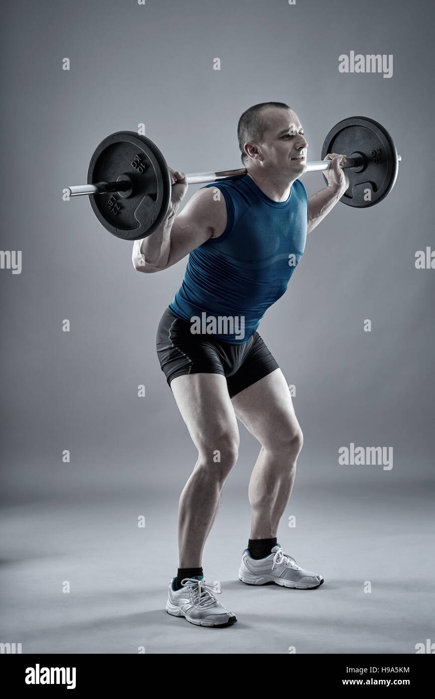 Uomo Fitness facendo squat con barbell sul retro del suo collo Foto Stock Uomo Fitness facendo squat con barbell sul retro del suo collo Foto Stock
