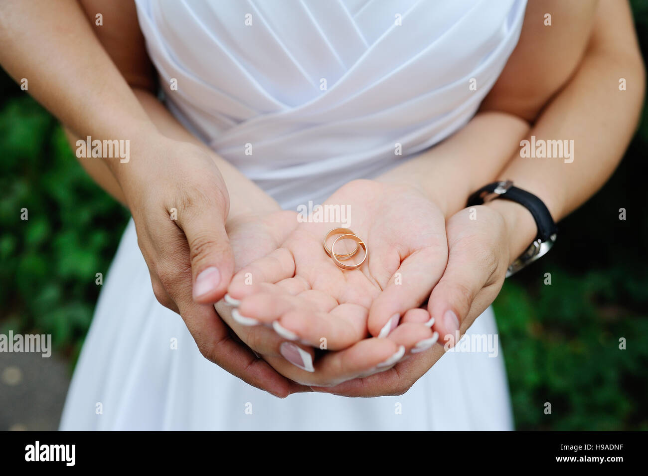 Gli anelli di nozze nella mani degli sposi novelli Foto stock - Alamy