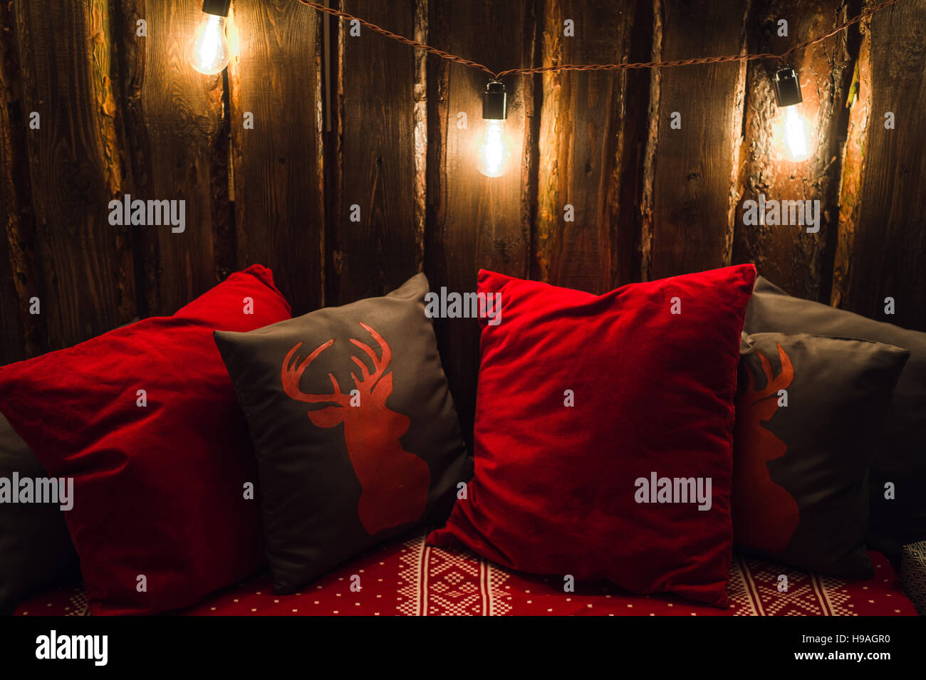 Testa di cervo su rosso fatto a mano cuscino sfondo di legno in interni Foto Stock