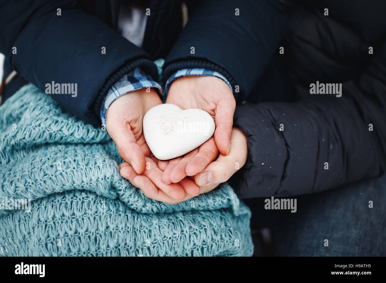 L uomo e la donna mani tenendo lo zenzero pane cuore in bianco ghiaccio, close-up. Il giorno di San Valentino vacanza. Foto Stock