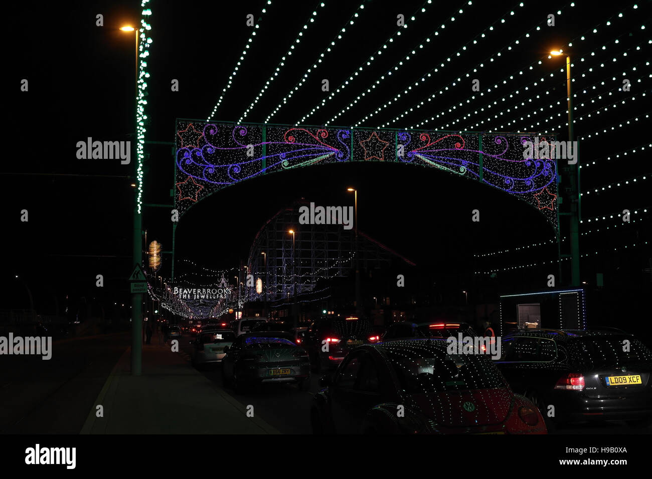 Vista notturna di Bling luminarie, vetture che riflette le luci verdi al di sotto del punto di donazione Archway, New South Promenade di Blackpool Foto Stock